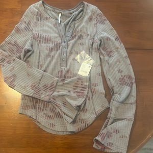 Free people light weight Henley style with bell sleeve opening.